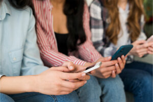 Gente joven usando redes sociales en sus teléfonos